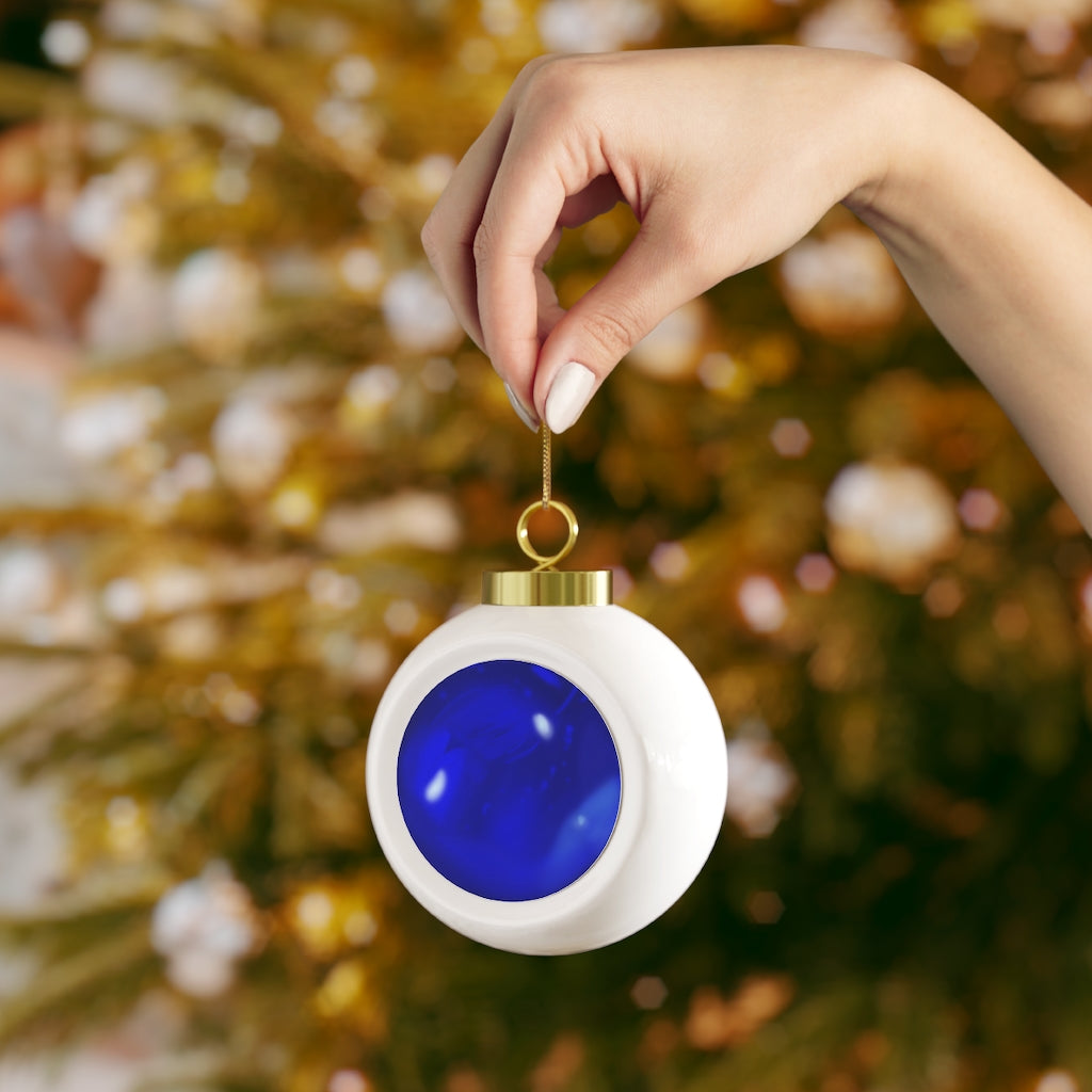 A beautiful blue ceramic Christmas ball ornament with a glossy finish, featuring a gold ribbon for hanging and a vintage design.