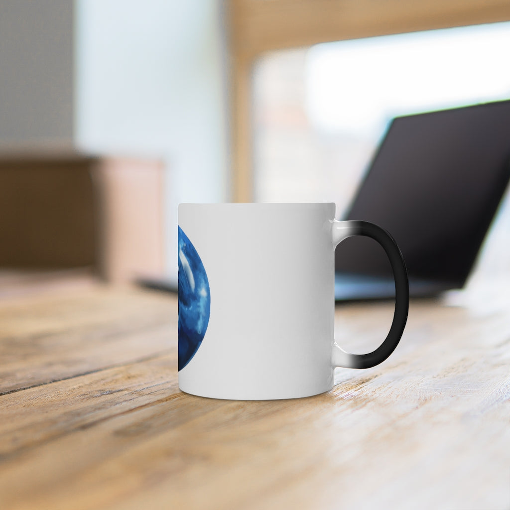 A blue ceramic mug that changes color when filled with hot liquid, showcasing its unique design and C-handle.