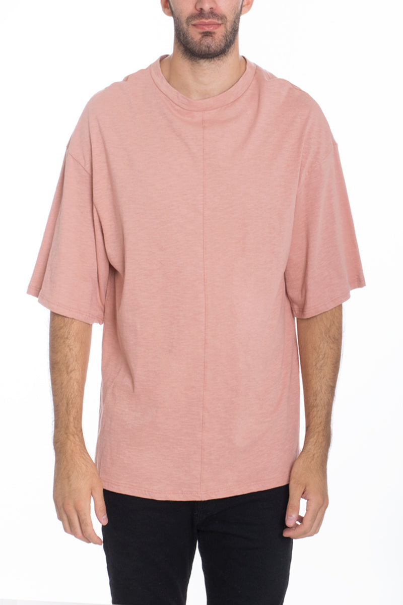 A stylish Box Tee made of 100% cotton, featuring a center seam and elbow-length sleeves, displayed on a model.