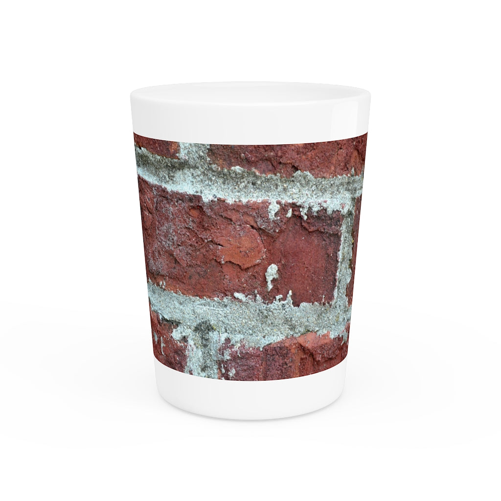 A personalized Brick Shot Glass made of white ceramic with a customizable design, featuring a black interior.