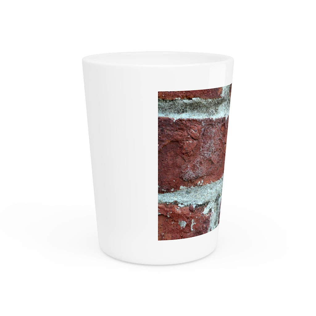 A personalized Brick Shot Glass made of white ceramic with a customizable design, featuring a black interior.