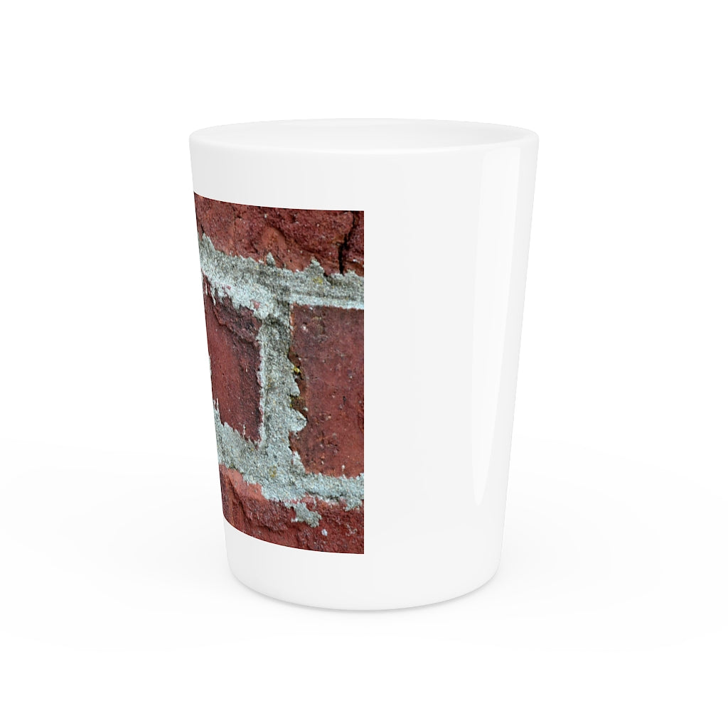 A personalized Brick Shot Glass made of white ceramic with a customizable design, featuring a black interior.