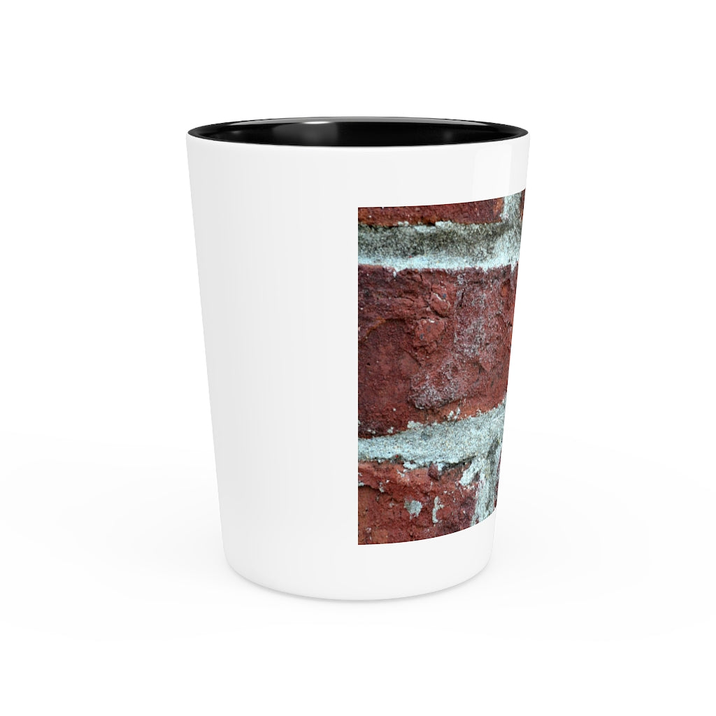 A personalized Brick Shot Glass made of white ceramic with a customizable design, featuring a black interior.