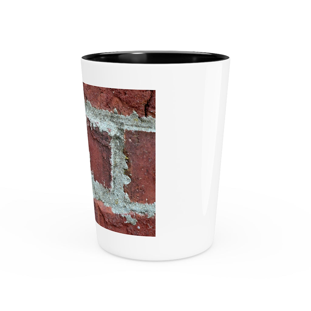 A personalized Brick Shot Glass made of white ceramic with a customizable design, featuring a black interior.