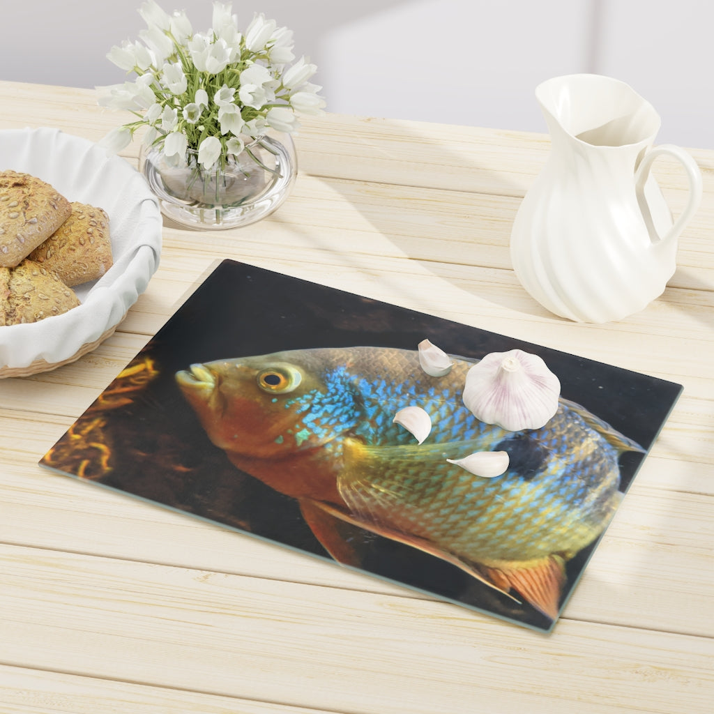 Brown and orange fish design tempered glass cutting board with rubber dots for stability.