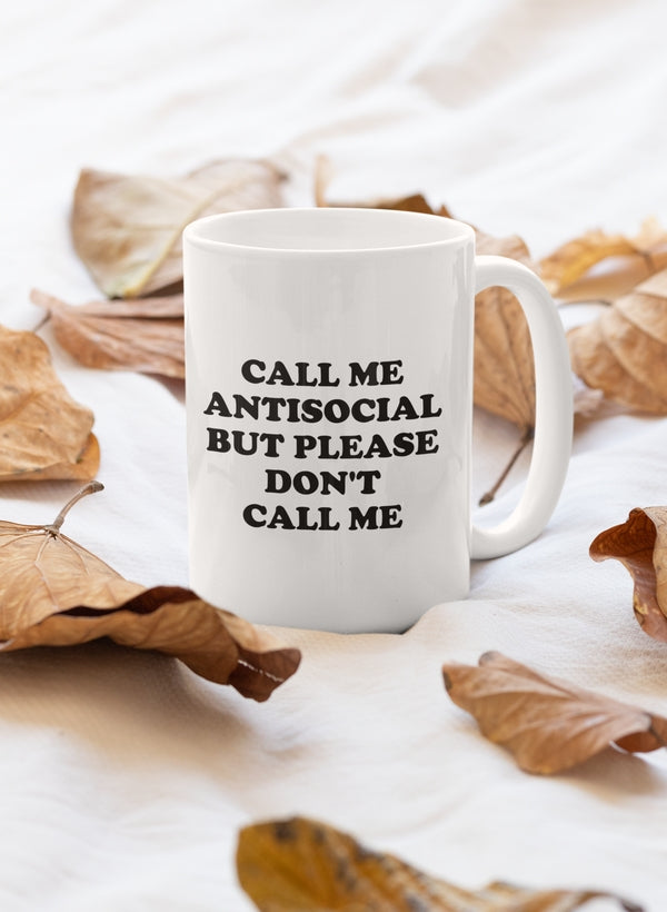 A stylish 11oz mug featuring the phrase 'Call Me Antisocial But Please Don't Mug' with a glossy finish and sturdy handle.