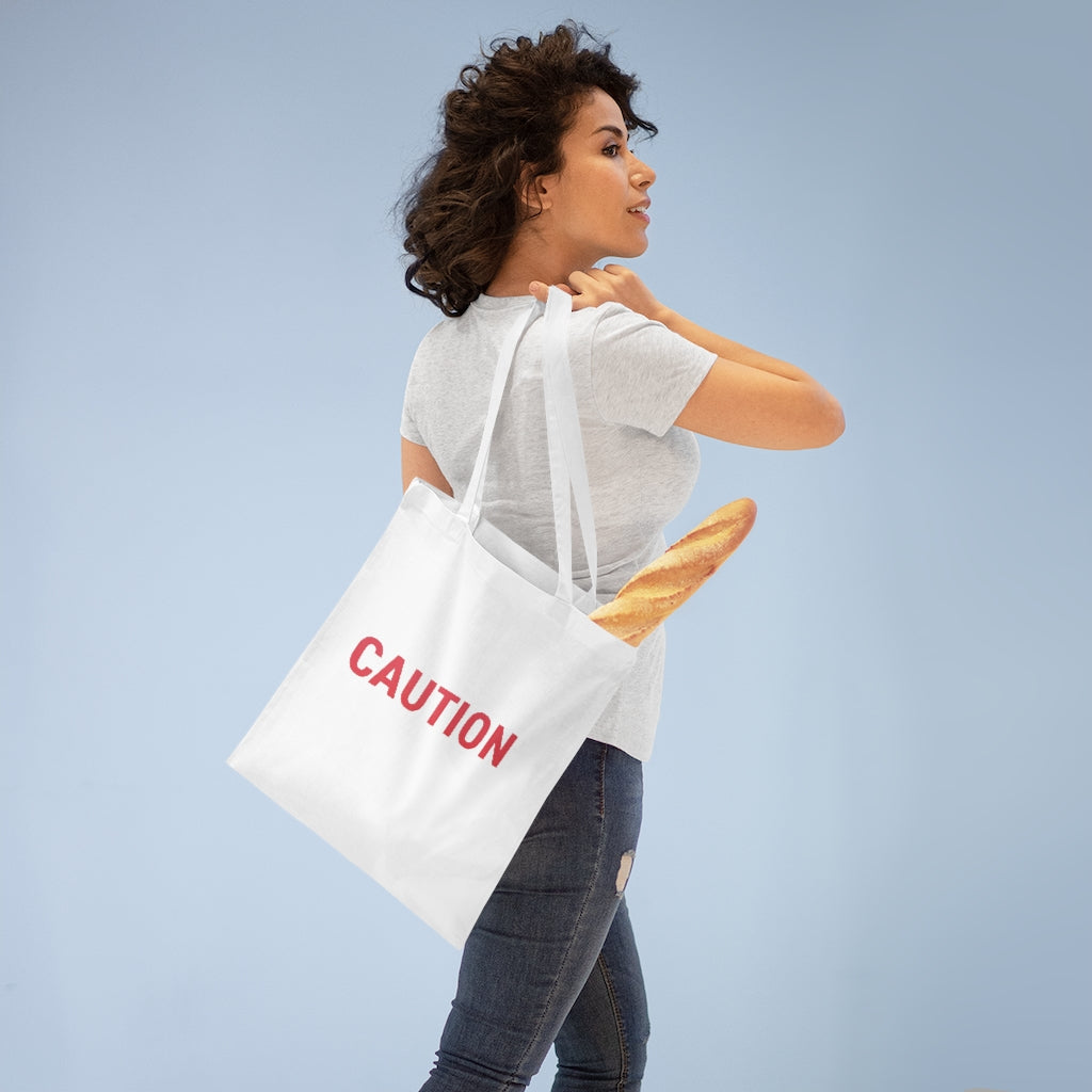 Caution Tote Bag made of 100% cotton with long handles and cross-stitched detailing, available in multiple colors.