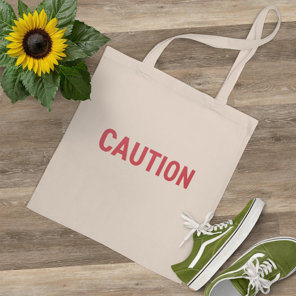 Caution Tote Bag made of 100% cotton with long handles and cross-stitched detailing, available in multiple colors.