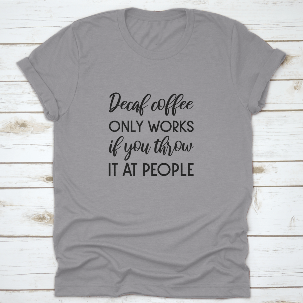 A humorous typography design shirt featuring the phrase 'Decaf Coffee Only Works If You Throw It At People', made from soft cotton fabric.