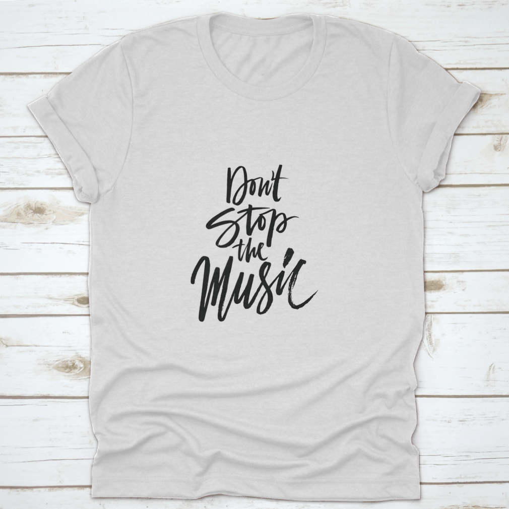 A stylish shirt featuring a hand-drawn quote 'Don'T Stop The Music' in a unique brush pen design, made from soft cotton fabric.