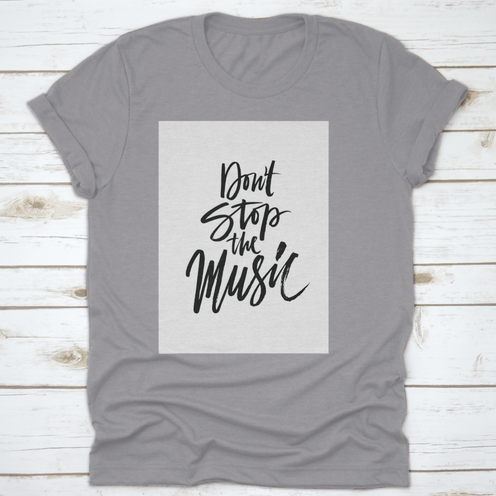 A stylish shirt featuring a hand-drawn quote 'Don'T Stop The Music' in a unique brush pen design, made from soft cotton fabric.