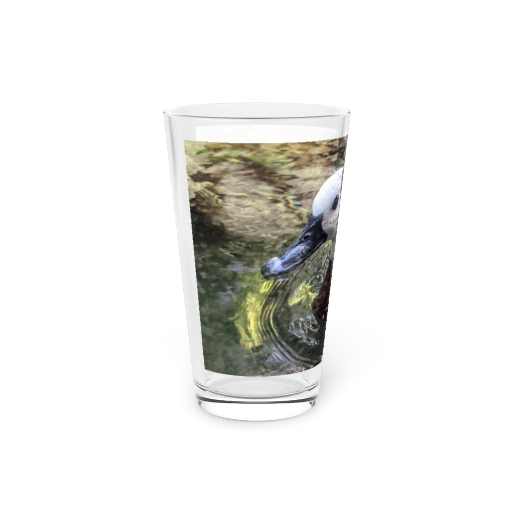 A clear 16oz Duck Pint Glass showcasing a custom printed design, perfect for beverages.