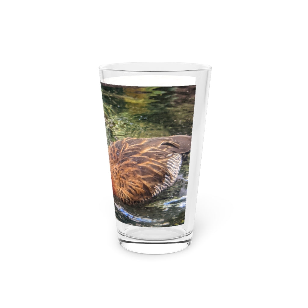 A clear 16oz Duck Pint Glass showcasing a custom printed design, perfect for beverages.