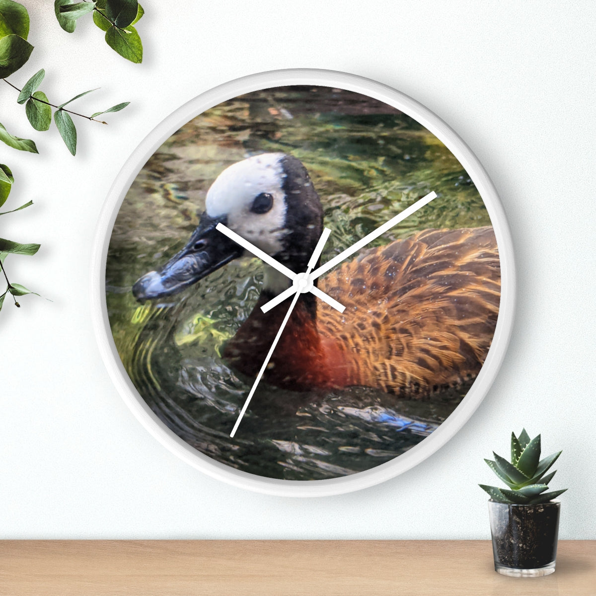 A charming Duck Wall Clock featuring a wooden frame and a plexiglass face, perfect for indoor decor.