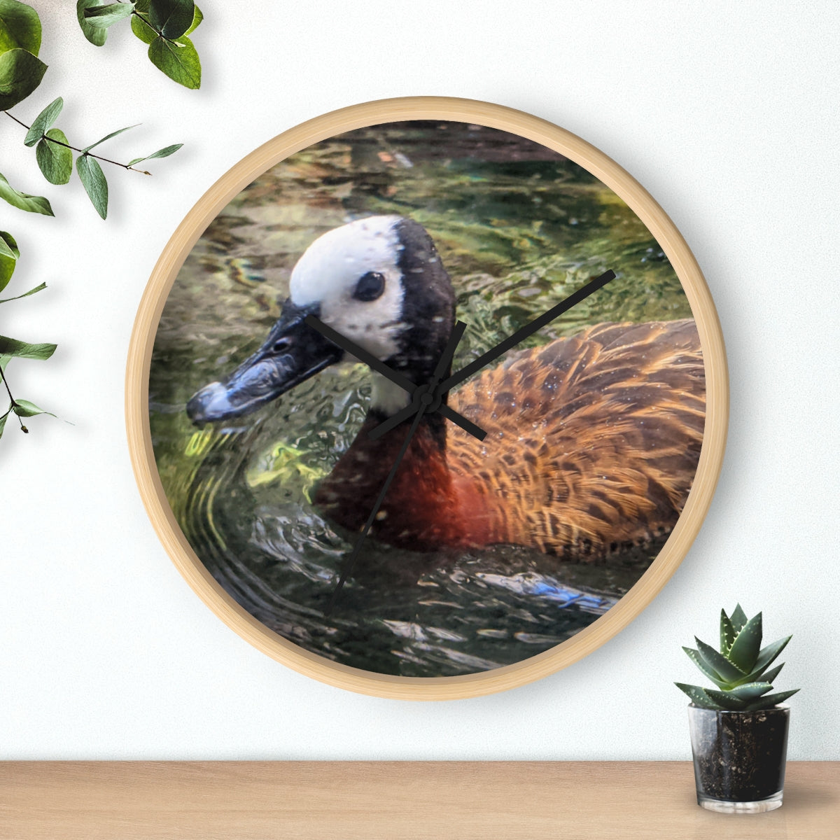 A charming Duck Wall Clock featuring a wooden frame and a plexiglass face, perfect for indoor decor.