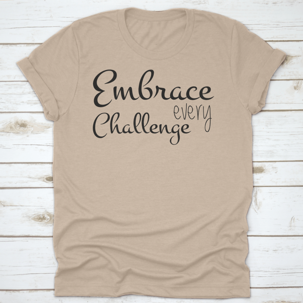 A motivational T-shirt featuring the quote 'Embrace Every Challenge', made from soft cotton fabric, displayed on a neutral background.