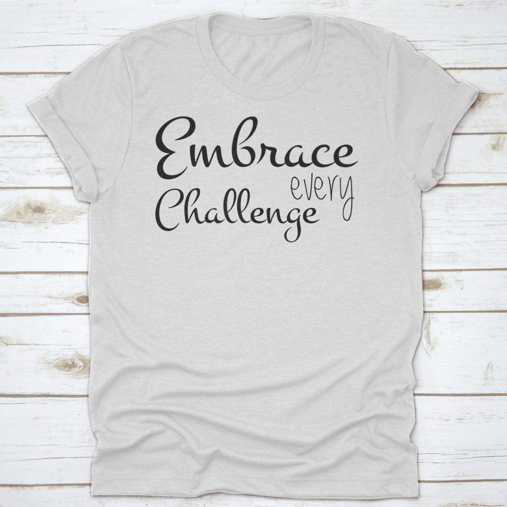 A motivational T-shirt featuring the quote 'Embrace Every Challenge', made from soft cotton fabric, displayed on a neutral background.