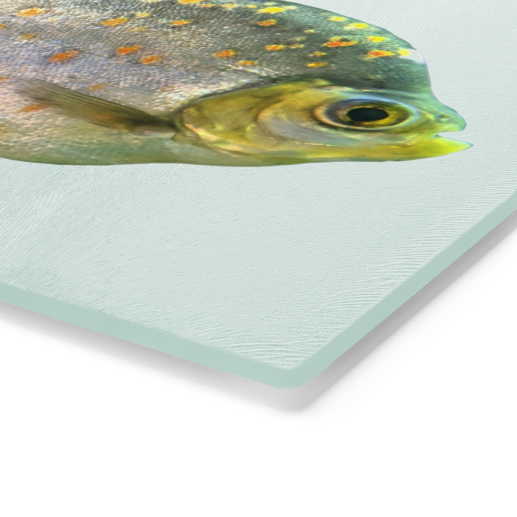 A stylish Fish with Specs Cutting Board made of tempered glass, featuring a unique fish design and four rubber dots for stability.