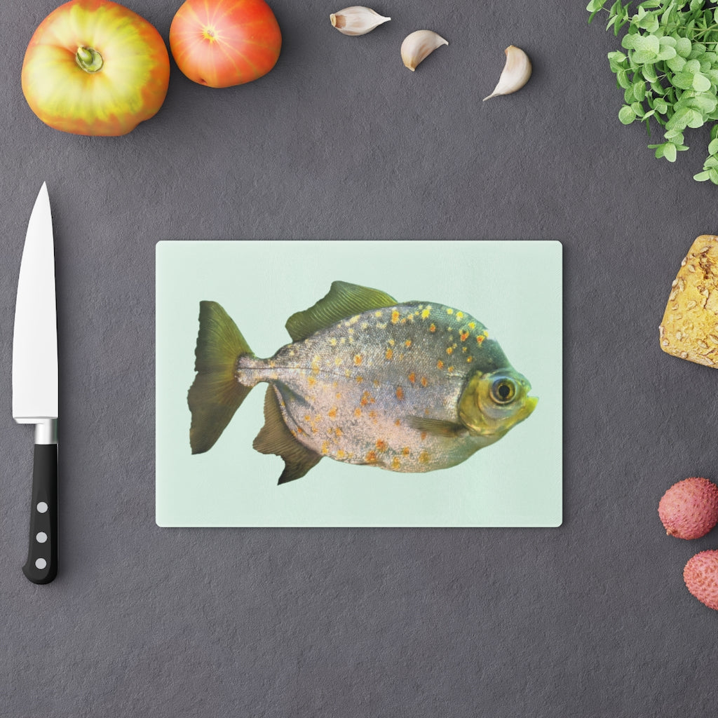 A stylish Fish with Specs Cutting Board made of tempered glass, featuring a unique fish design and four rubber dots for stability.