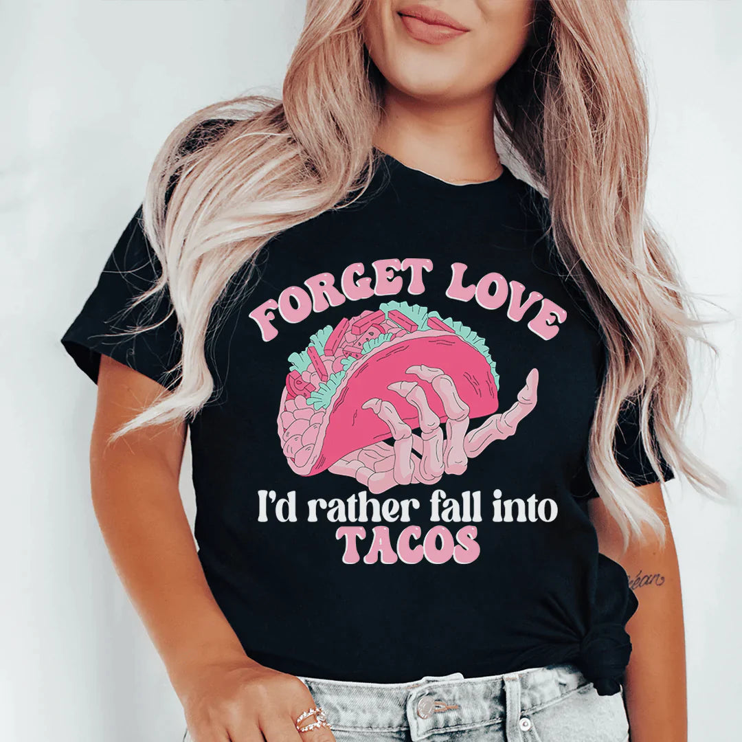 A humorous t-shirt featuring the phrase 'Forget Love I'd Rather Fall Into Tacos', made from soft cotton with double stitching.