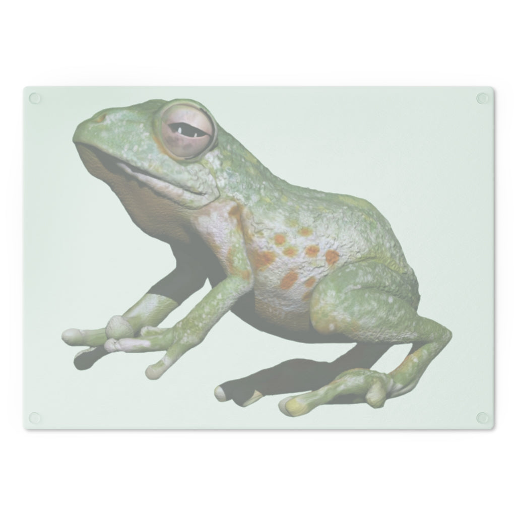 A vibrant frog-themed tempered glass cutting board with rubber dots for stability, perfect for kitchen use.