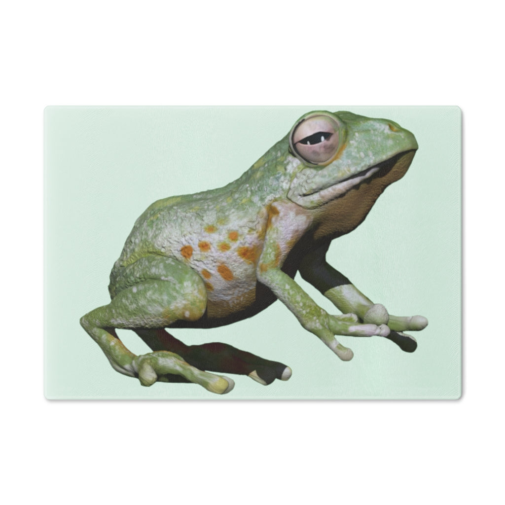 A vibrant frog-themed tempered glass cutting board with rubber dots for stability, perfect for kitchen use.