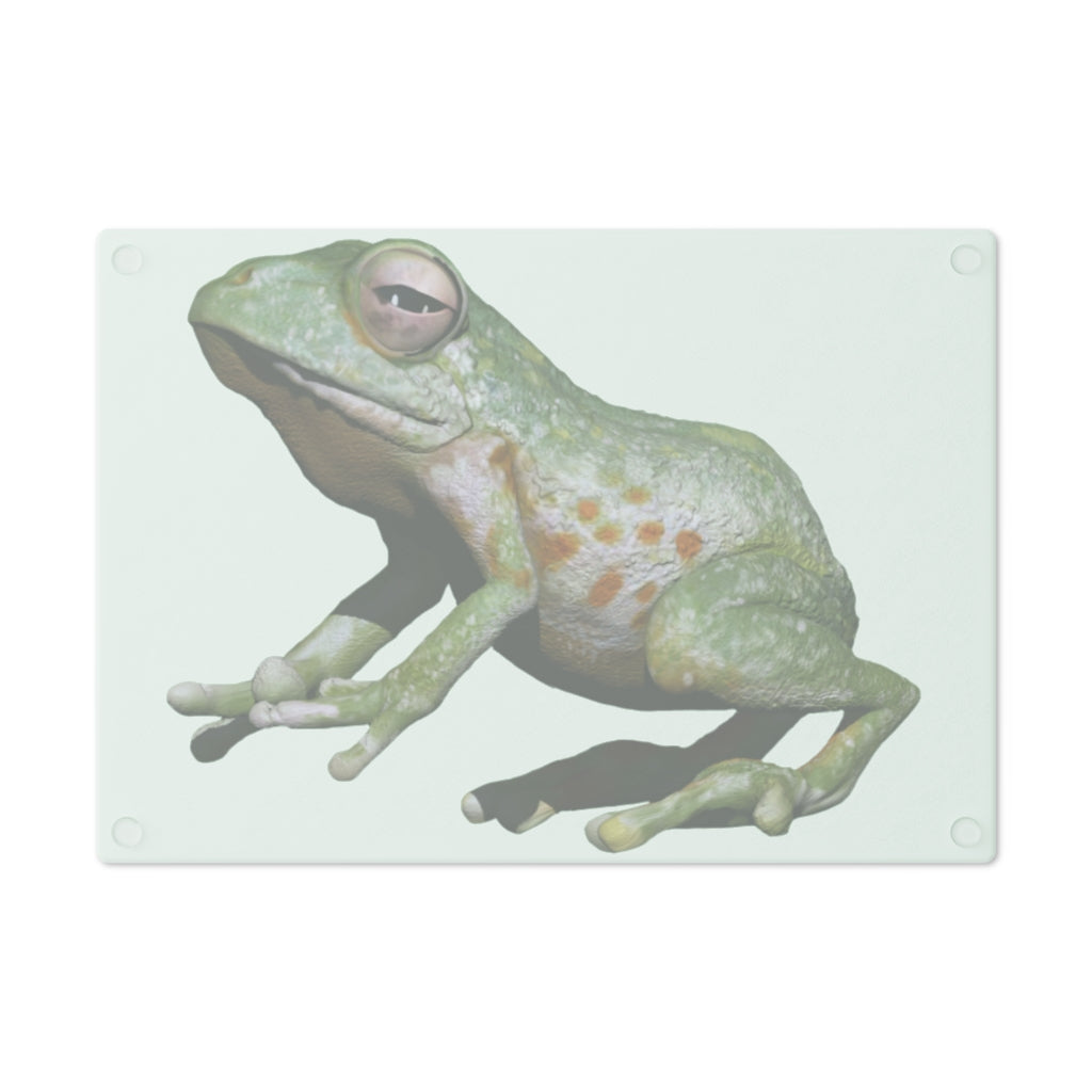 A vibrant frog-themed tempered glass cutting board with rubber dots for stability, perfect for kitchen use.