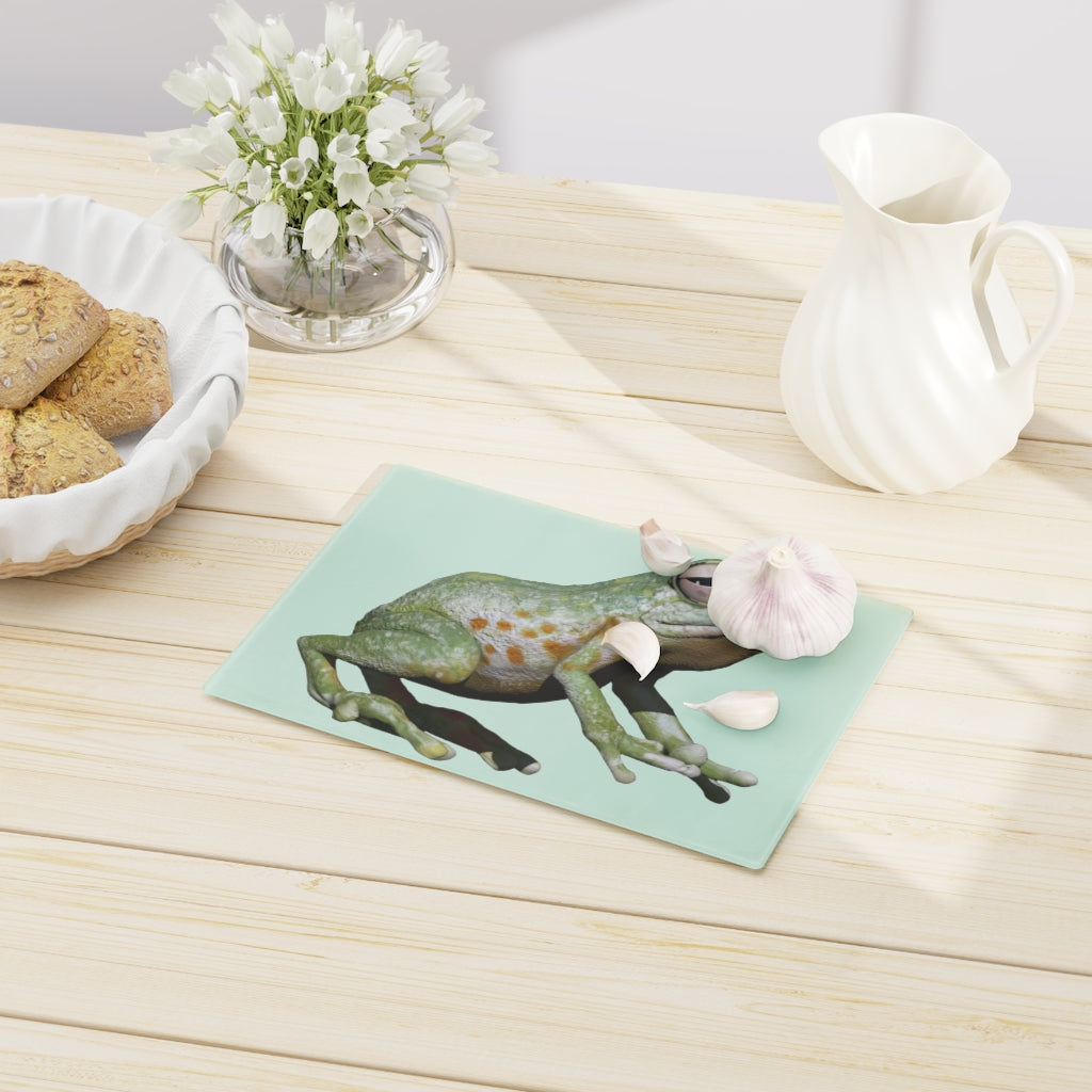 A vibrant frog-themed tempered glass cutting board with rubber dots for stability, perfect for kitchen use.