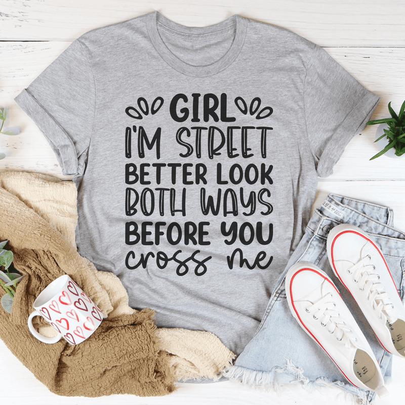 A stylish black t-shirt featuring the phrase 'Girl I'm Street Better Look Both Ways Before You Cross Me' printed in bold letters.