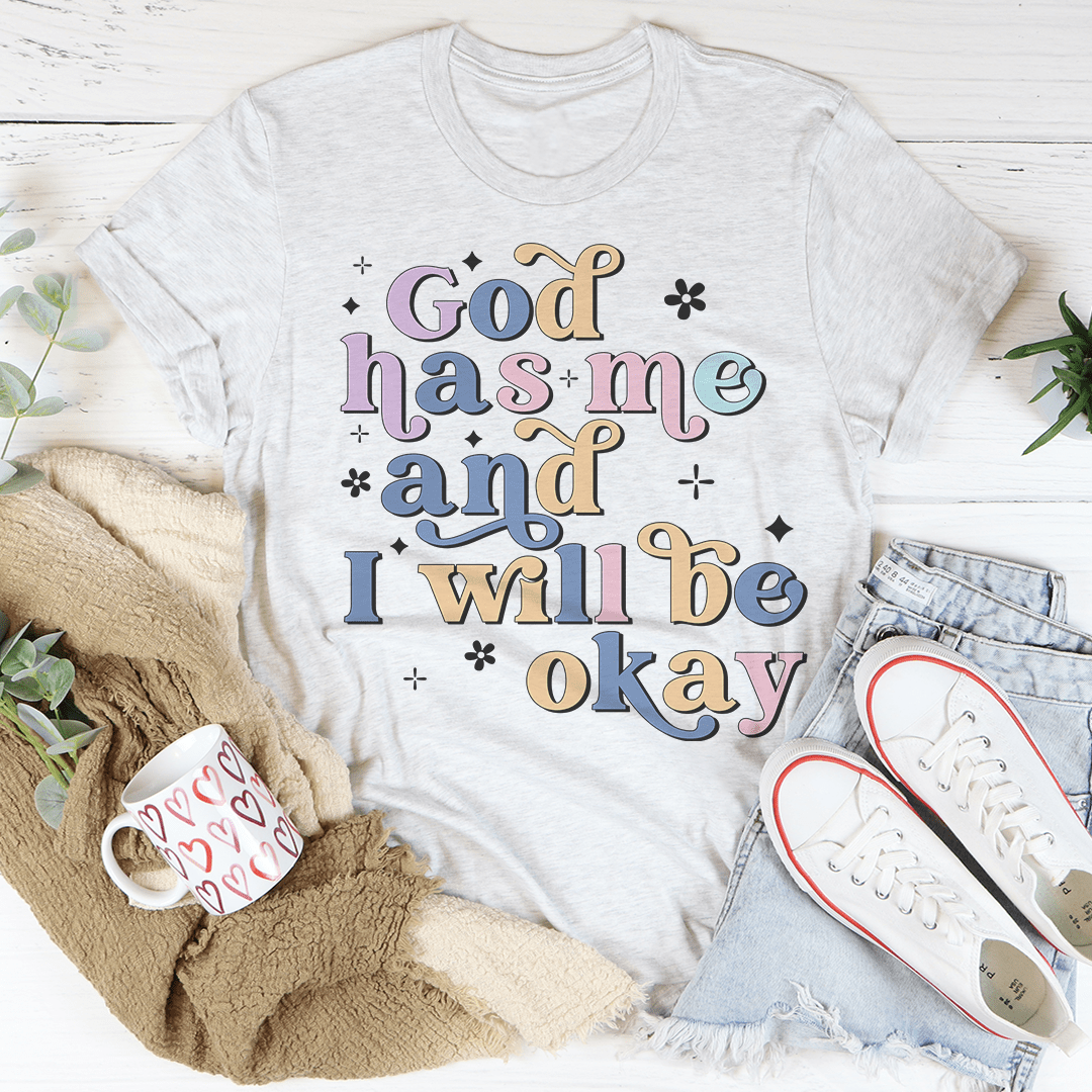 A comfortable God Has Me And I Will Be Okay T-Shirt made from soft ring-spun cotton, featuring a positive message printed on the front.