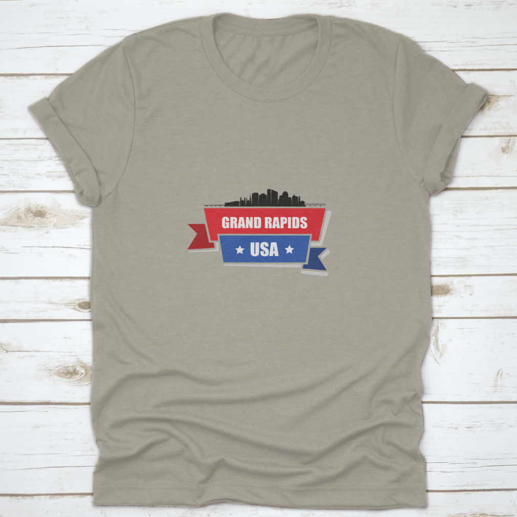 A stylish t-shirt featuring the Grand Rapids skyline design with red and blue ribbons, made from 100% cotton.