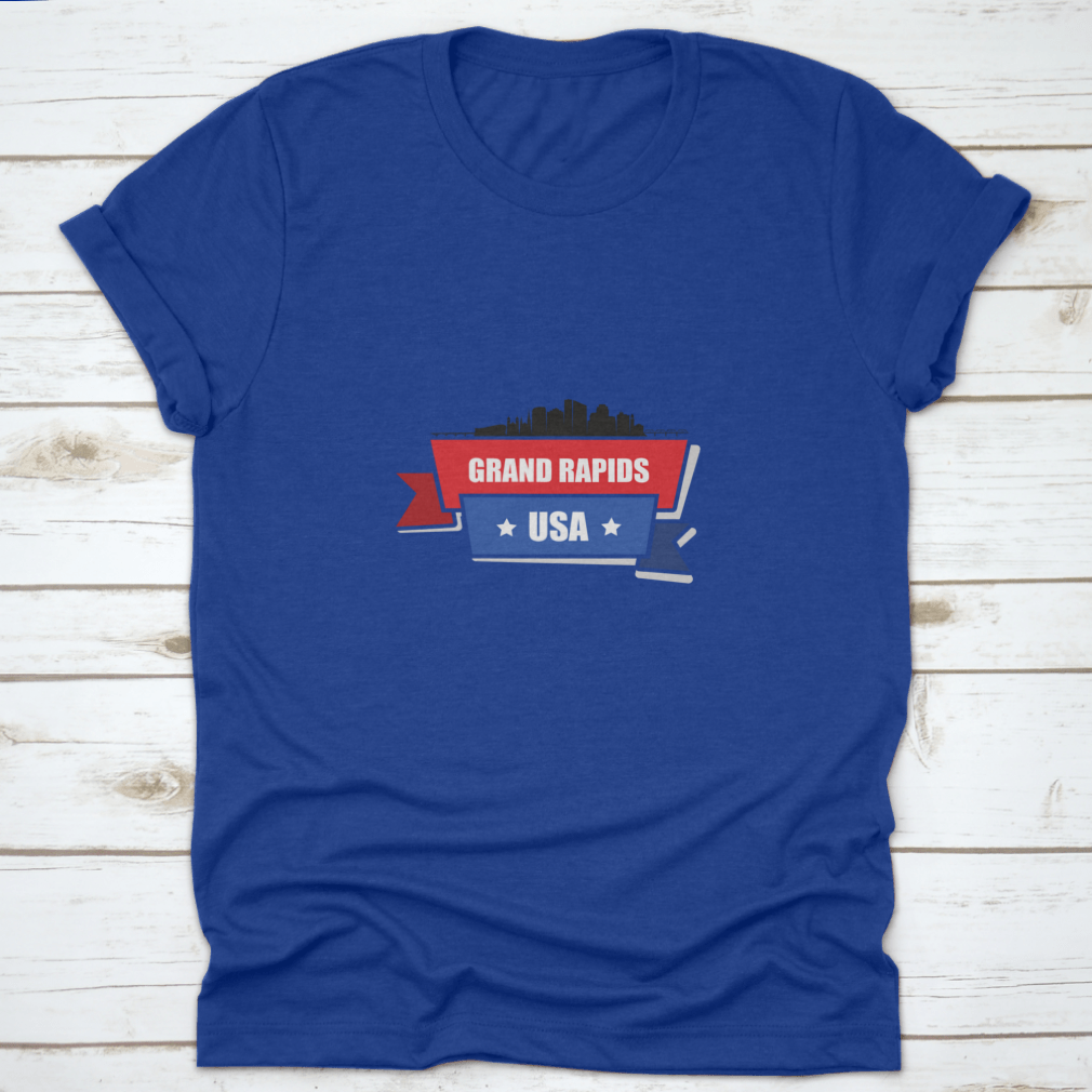 A stylish t-shirt featuring the Grand Rapids skyline design with red and blue ribbons, made from 100% cotton.