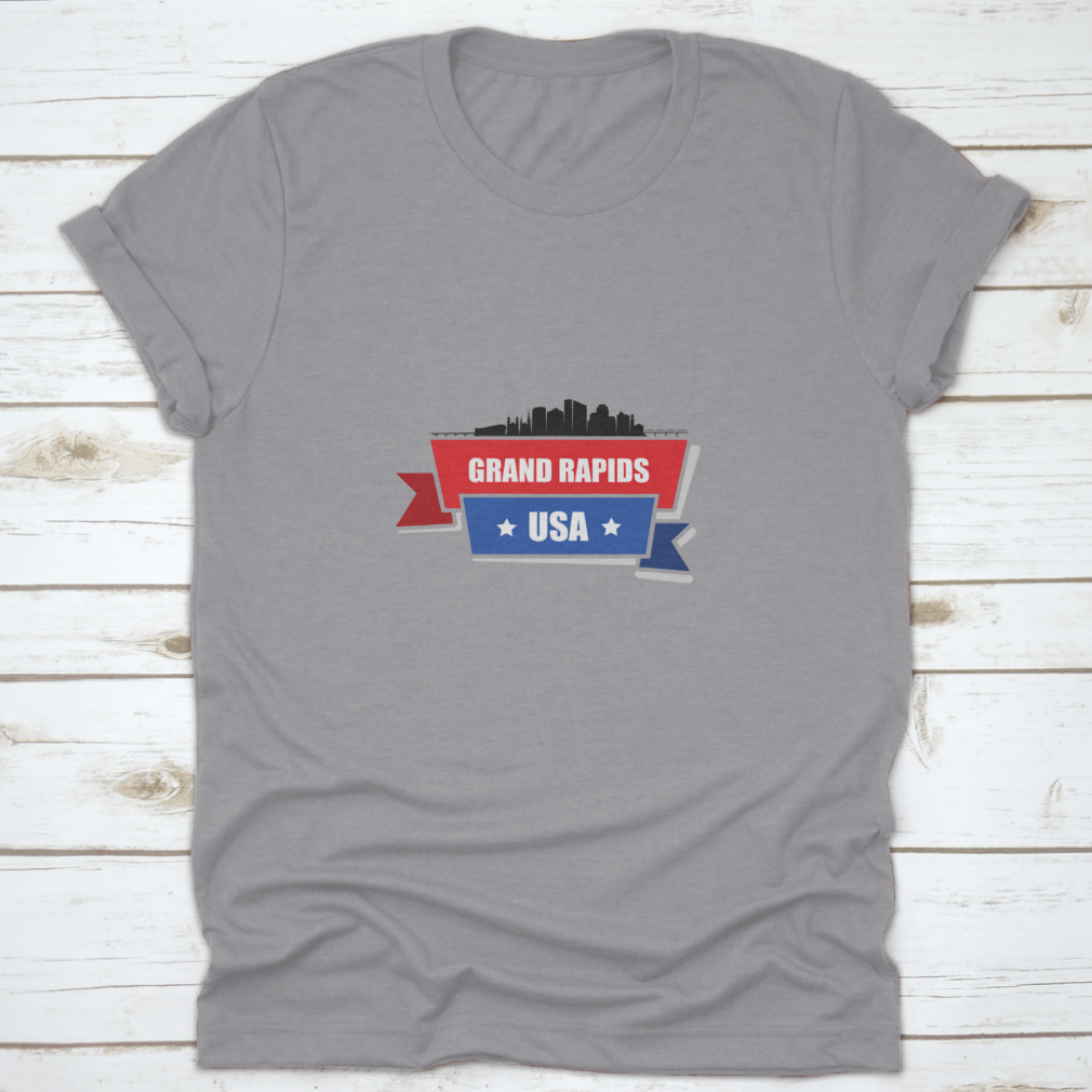 A stylish t-shirt featuring the Grand Rapids skyline design with red and blue ribbons, made from 100% cotton.