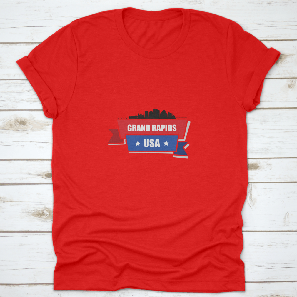 A stylish t-shirt featuring the Grand Rapids skyline design with red and blue ribbons, made from 100% cotton.