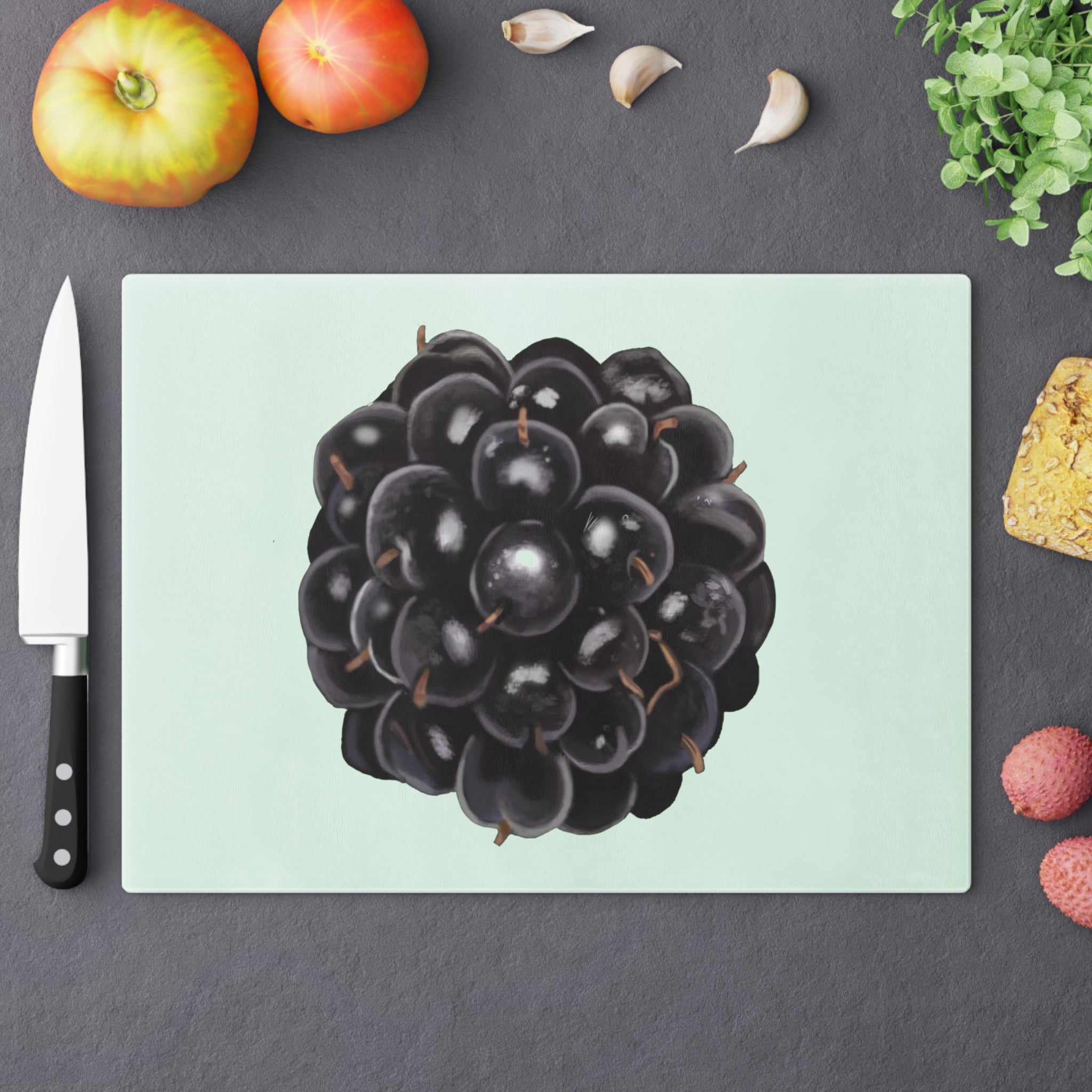 A stylish Grape Cutting Board made of tempered glass with a grape design, featuring four rubber dots for stability.