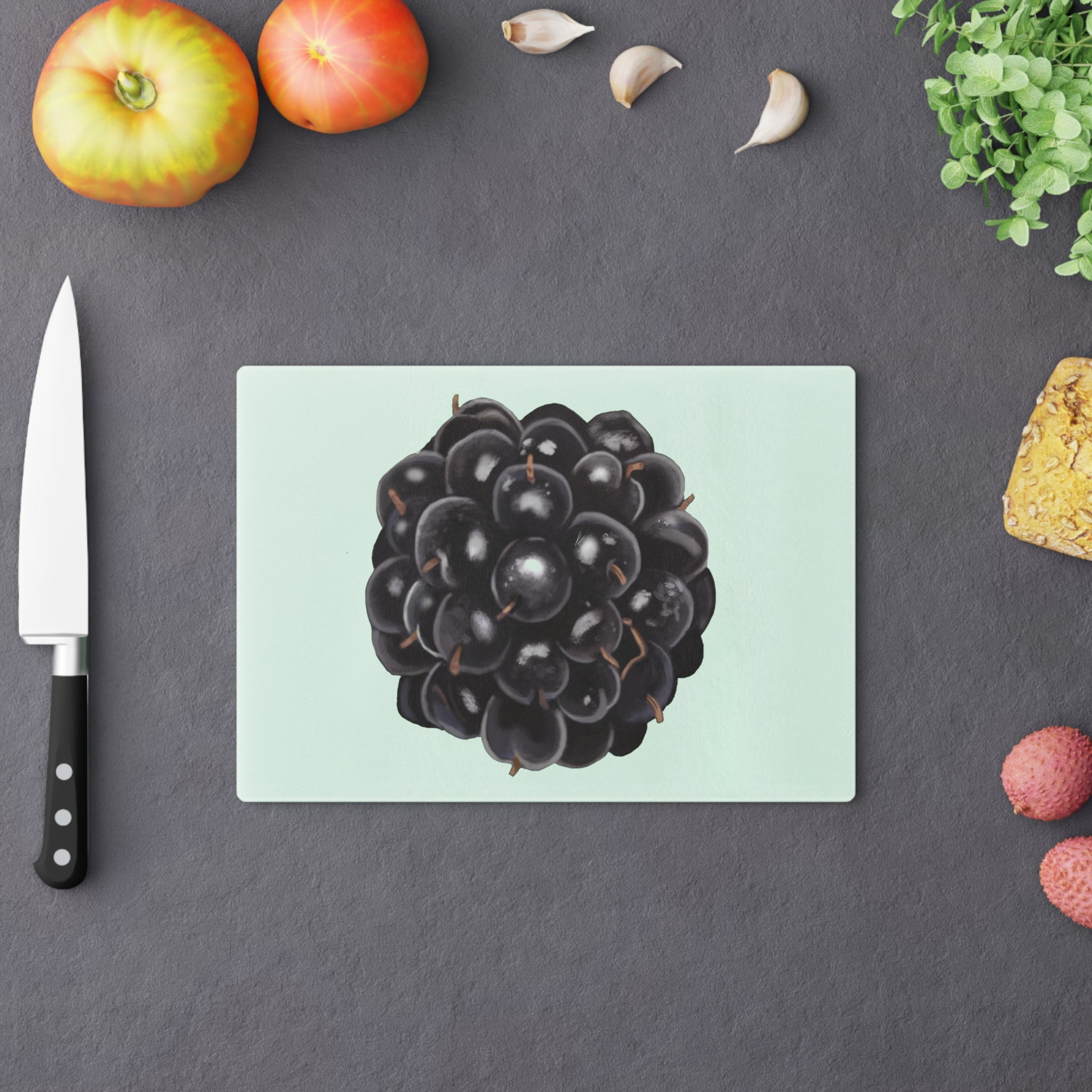 A stylish Grape Cutting Board made of tempered glass with a grape design, featuring four rubber dots for stability.