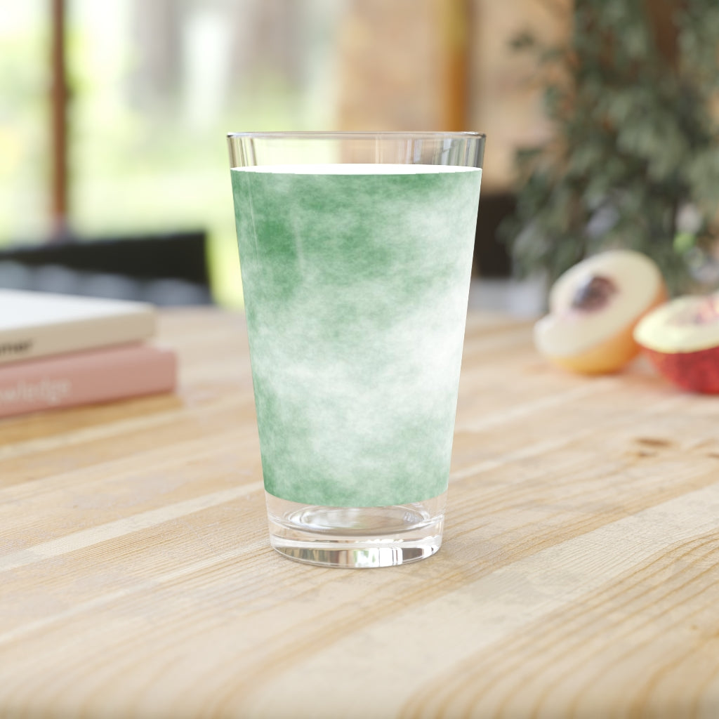 A clear 16oz pint glass featuring a green cloud design, perfect for personalized beverages.