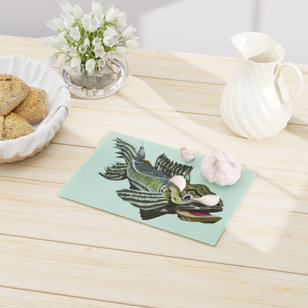 A stylish green fish cutting board made of tempered glass, featuring a unique fish design and four rubber dots for stability.