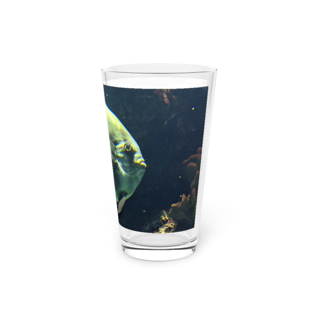 A clear 16oz pint glass featuring a green fish design, perfect for personalized beverages.