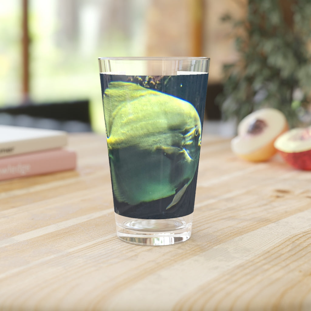 A clear 16oz pint glass featuring a green fish design, perfect for personalized beverages.