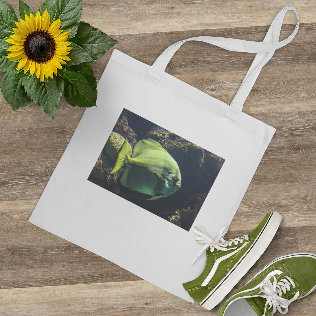 A vibrant Green Fish Tote Bag made of 100% cotton, featuring long cross-stitched handles for added stability.