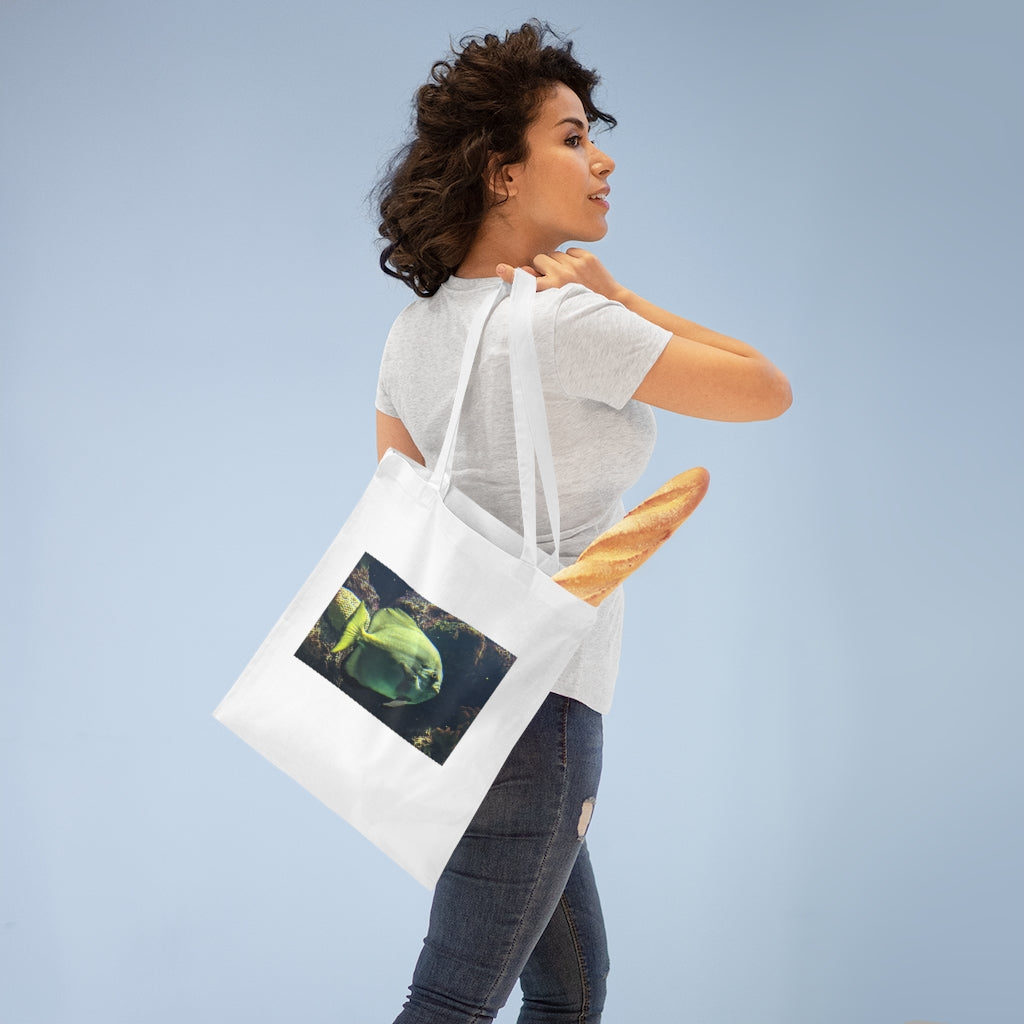 A vibrant Green Fish Tote Bag made of 100% cotton, featuring long cross-stitched handles for added stability.