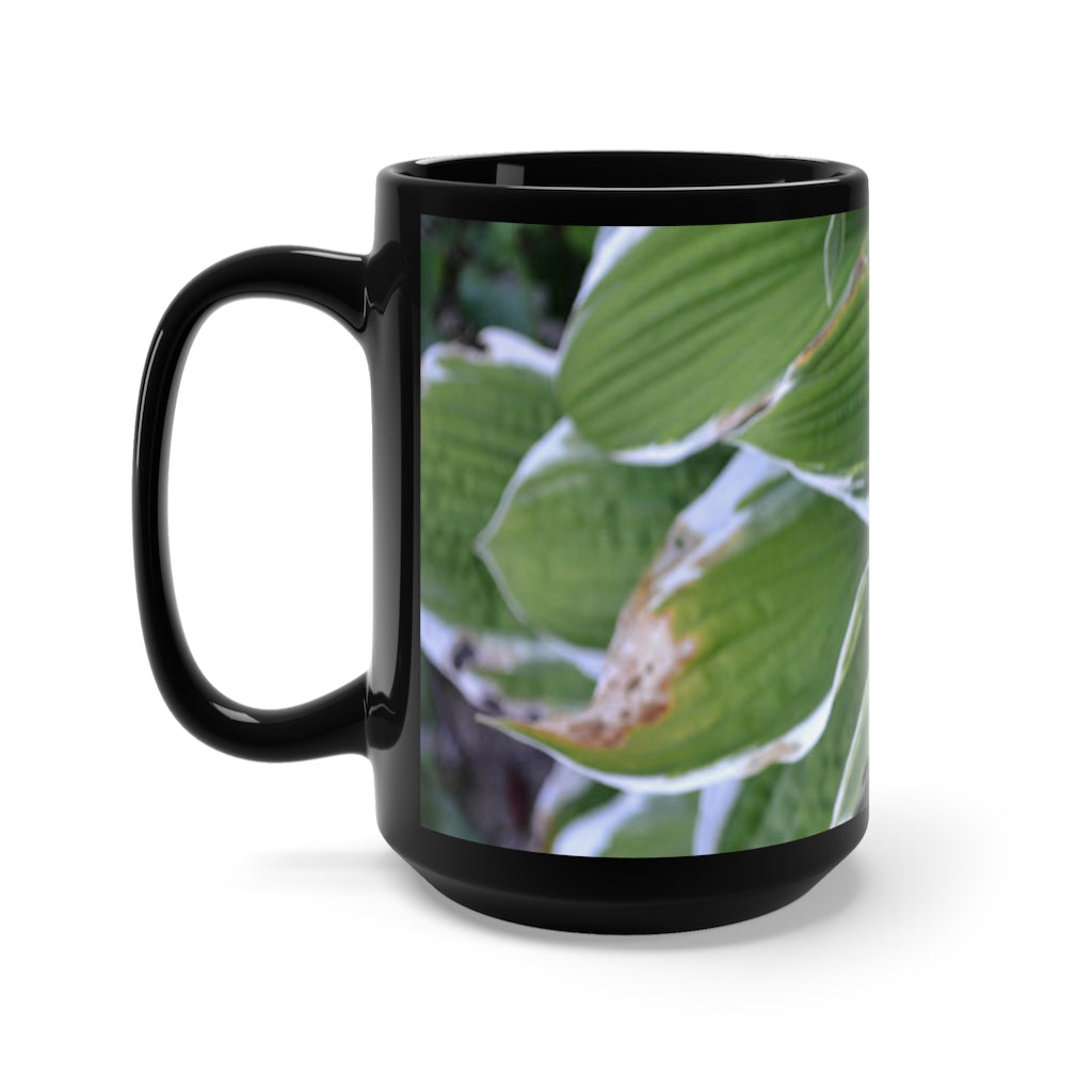 A stylish 15oz black ceramic mug featuring green leaves design, perfect for coffee and tea lovers.