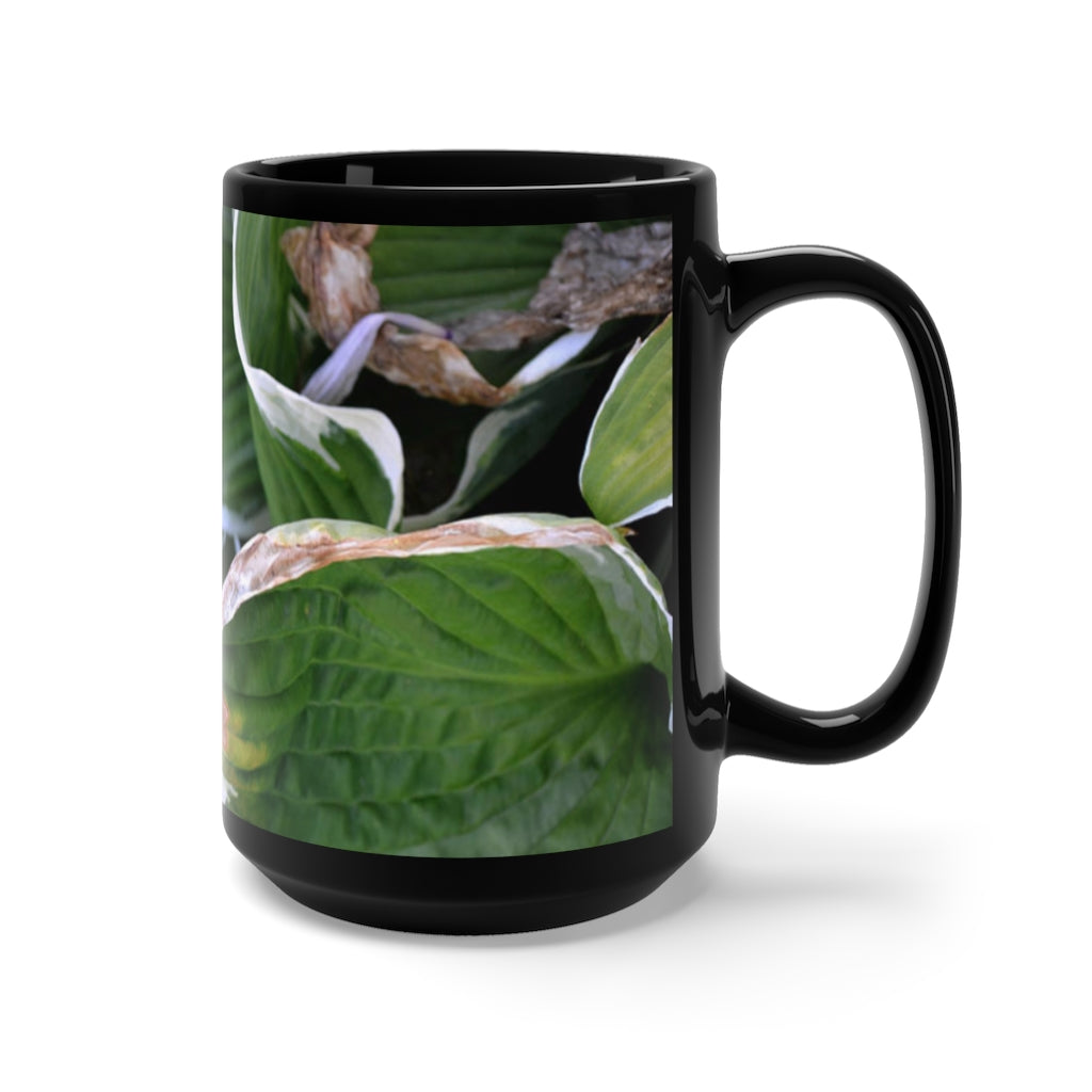 A stylish 15oz black ceramic mug featuring green leaves design, perfect for coffee and tea lovers.