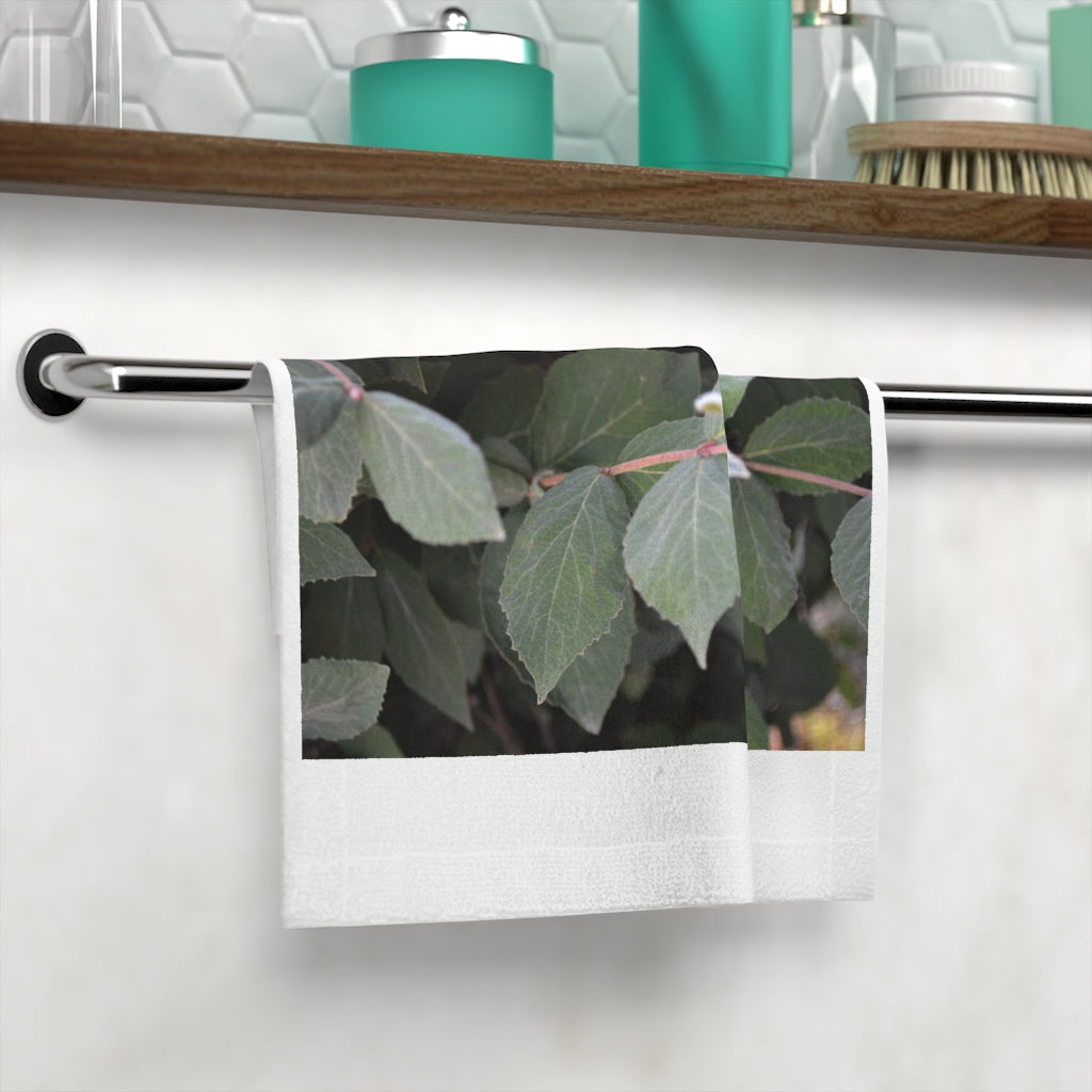 A stylish Green Leaves Face Towel featuring a vibrant printed design on a soft polyester front and absorbent cotton back, perfect for bathroom use.