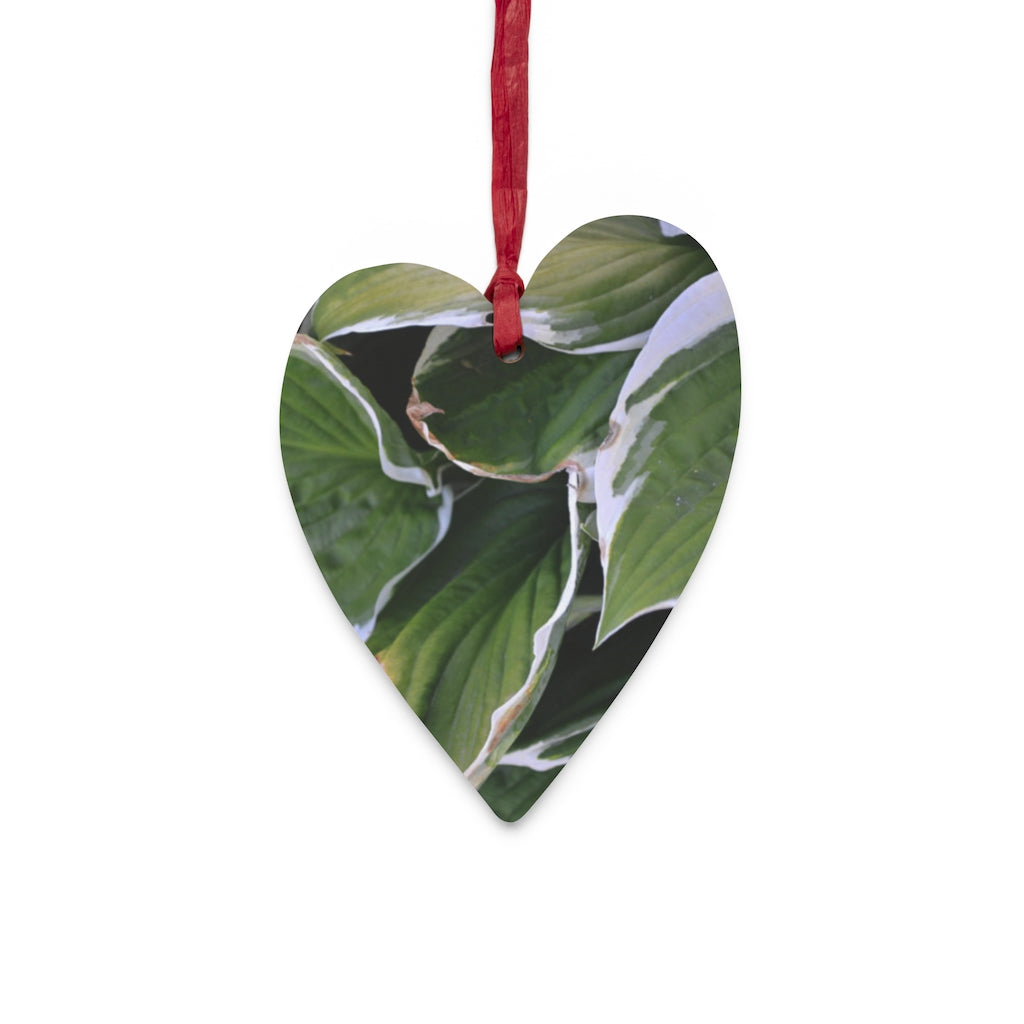 A collection of Green Leaves Wooden Christmas Ornaments in various whimsical shapes, featuring a rustic wooden finish and red hanging ribbons.