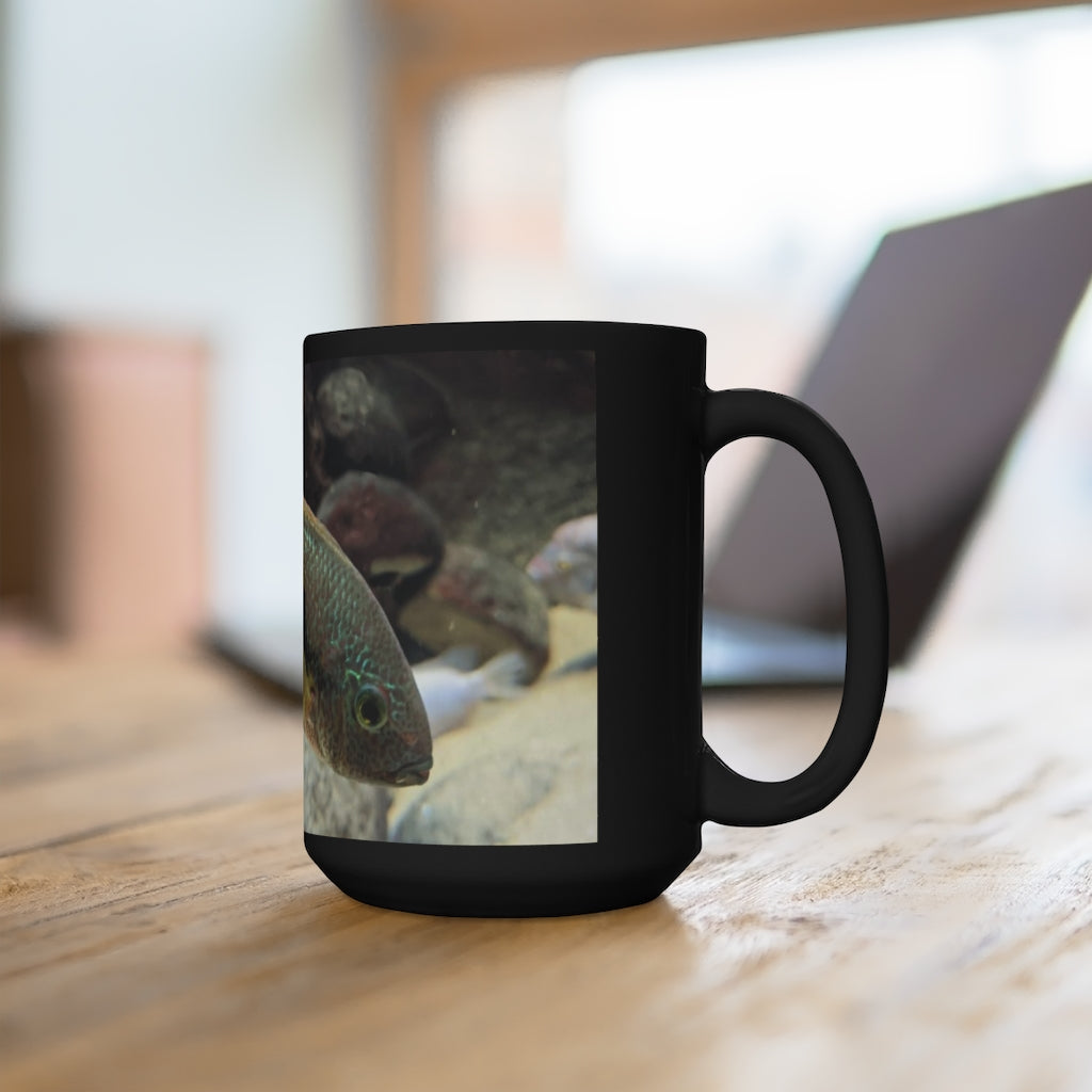 A stylish black ceramic mug featuring a grey and orange fish design, perfect for coffee and tea lovers, with a 15oz capacity.