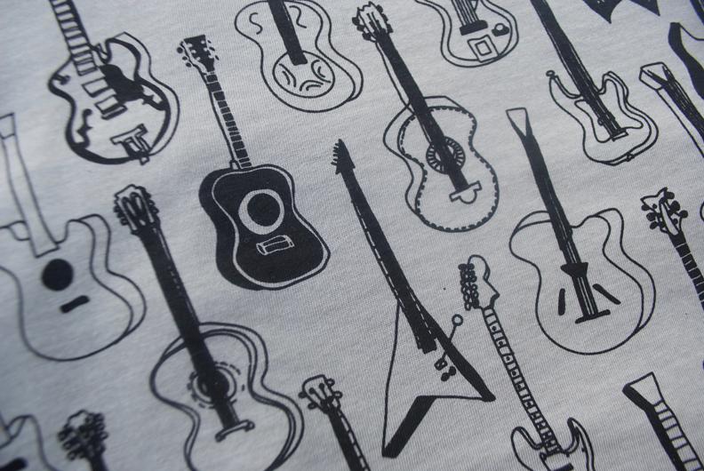 Guitars Pattern Heather Stone T-Shirt featuring a unique guitar design in black ink on a soft heather stone fabric.