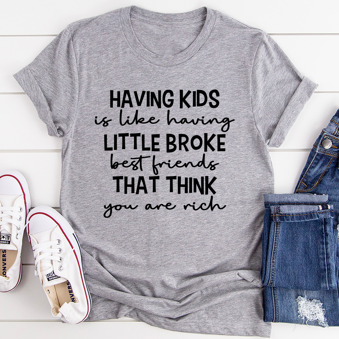 A humorous t-shirt featuring the phrase 'Having Kids Is Like Having Little Broke Friends', made from soft cotton with double stitching.