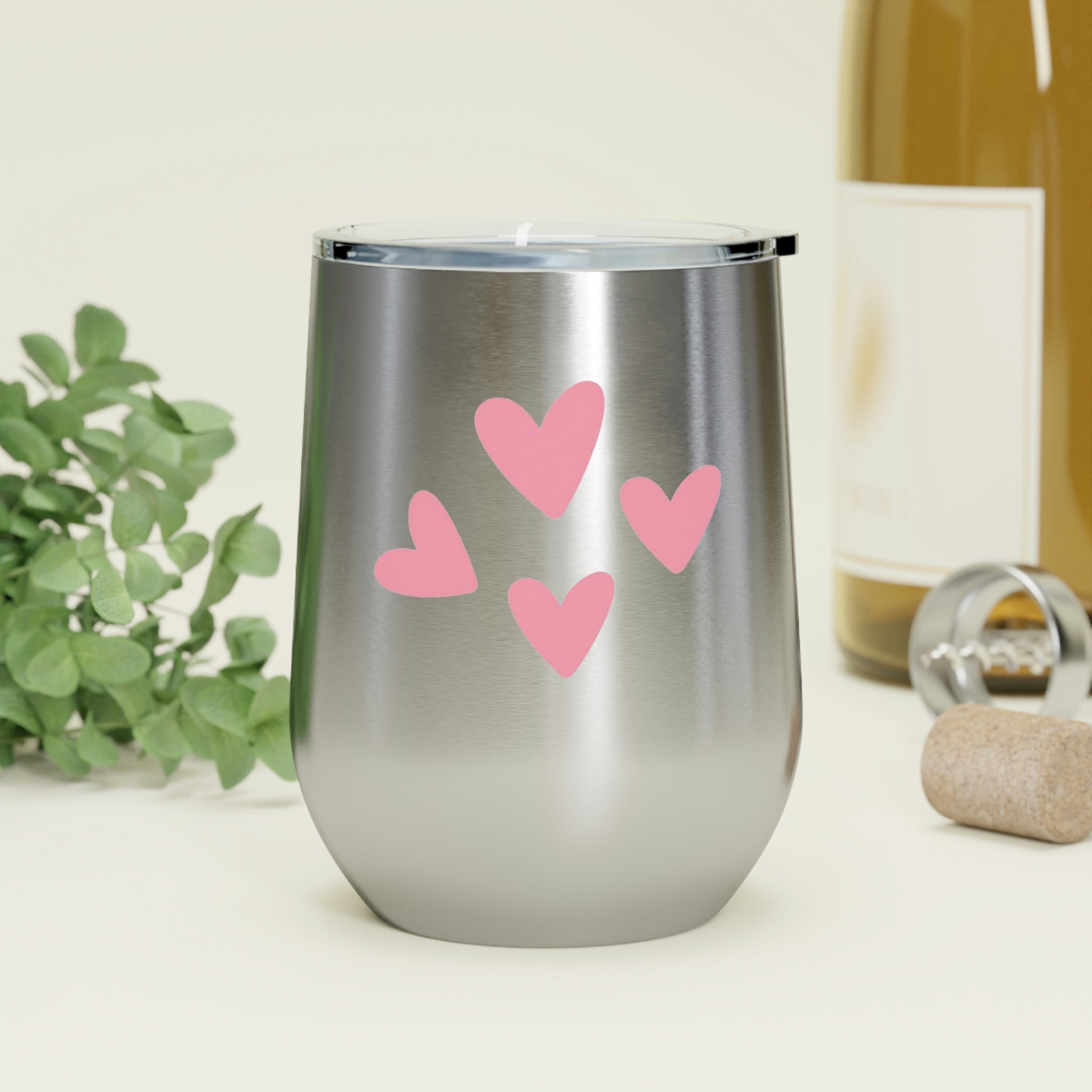 A stylish Hearts Wine Tumbler made of stainless steel with a clear plastic lid, perfect for hot and cold beverages.